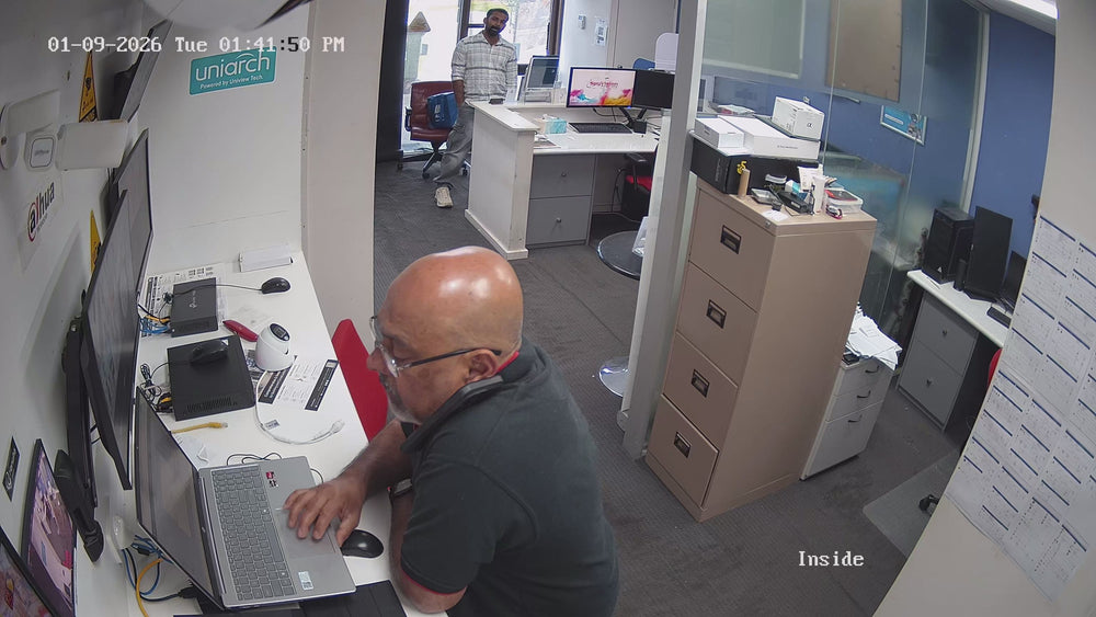 CCTV Tradie team member in front of shelves of security cameras